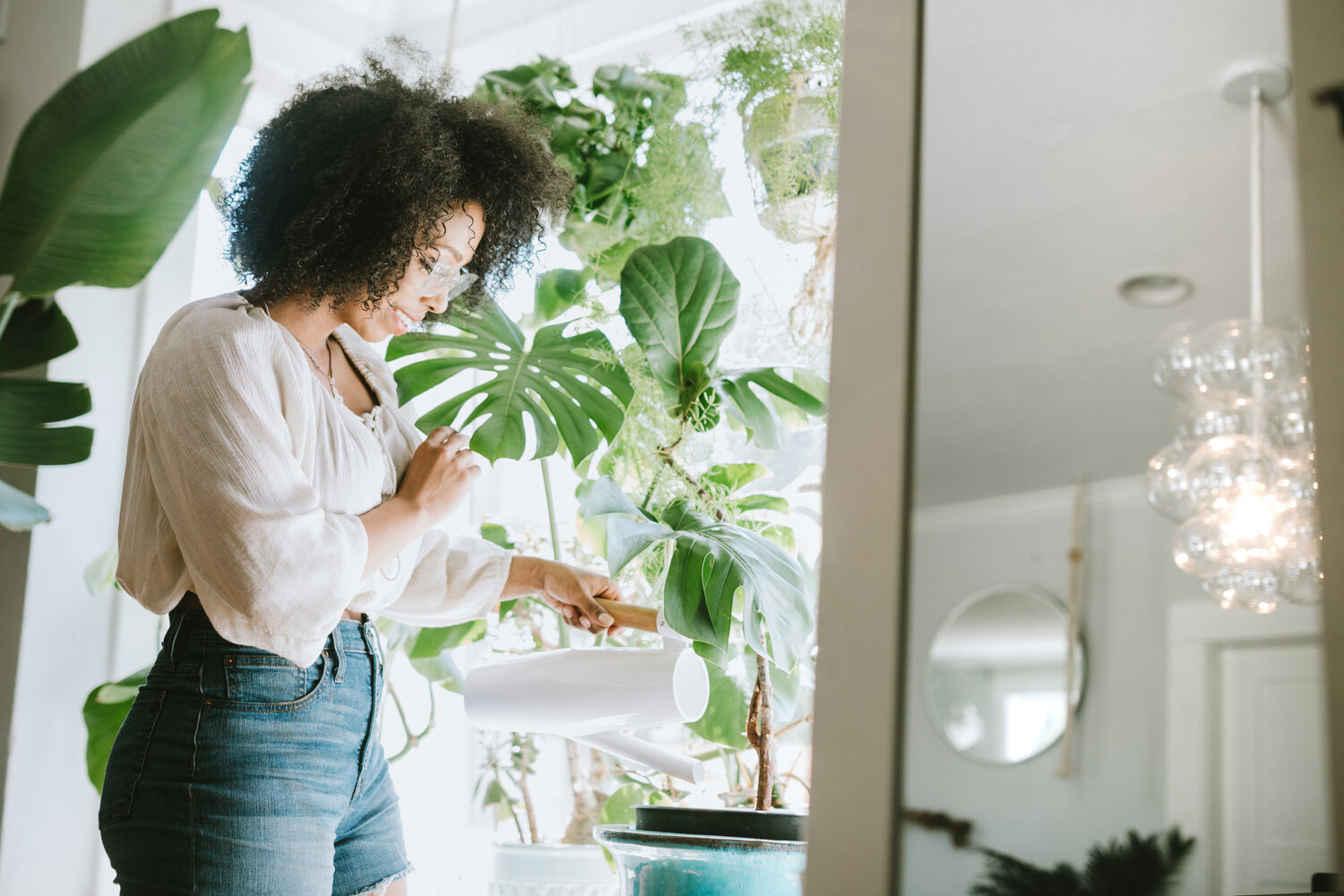 mulher regando plantas dentro de casa