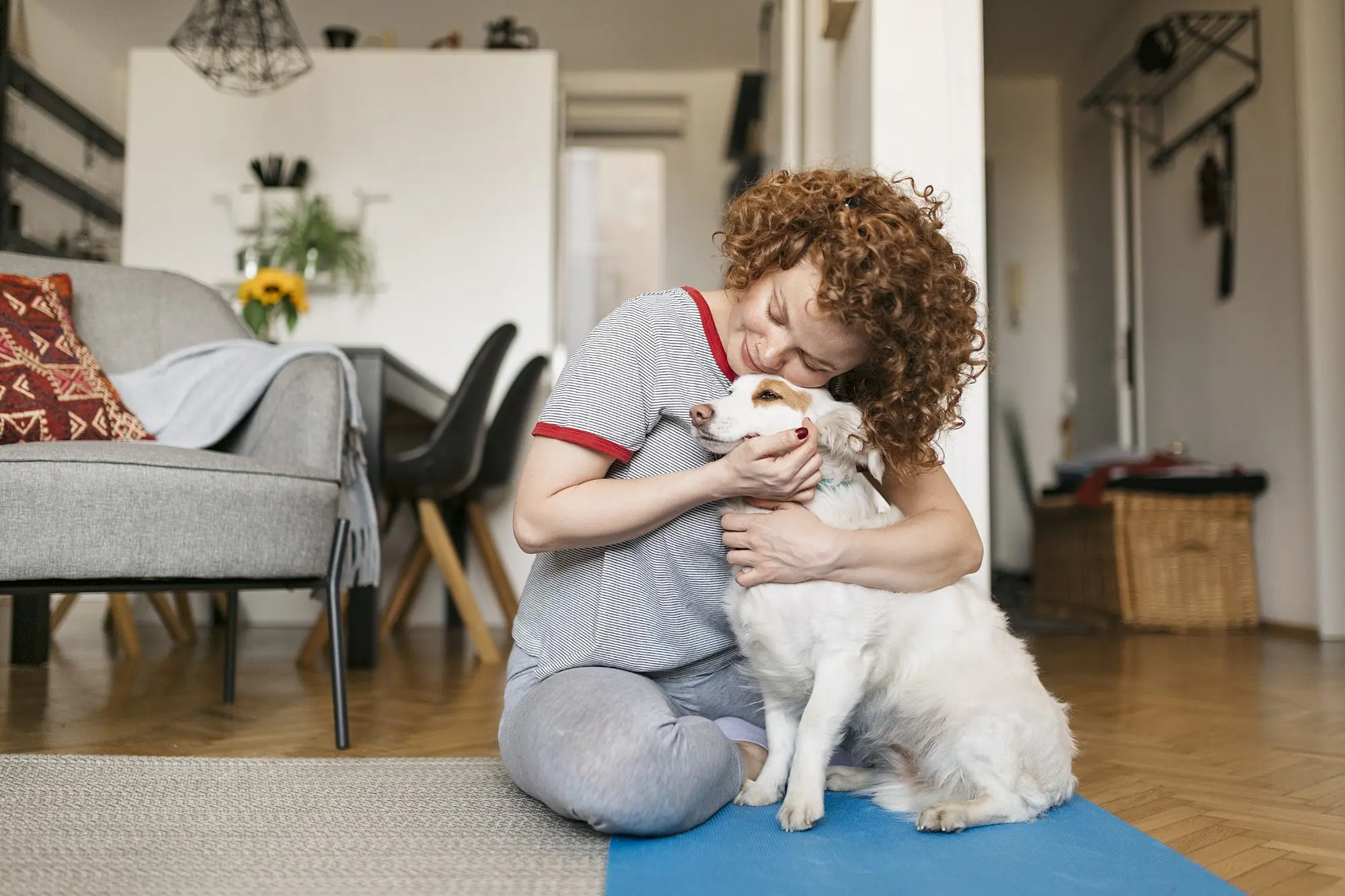 mulher abraçando cachorro em espaço pequeno