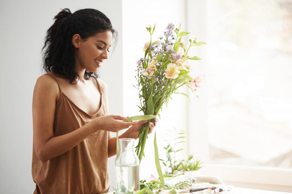 mulher arrumando flores para colocar em vaso