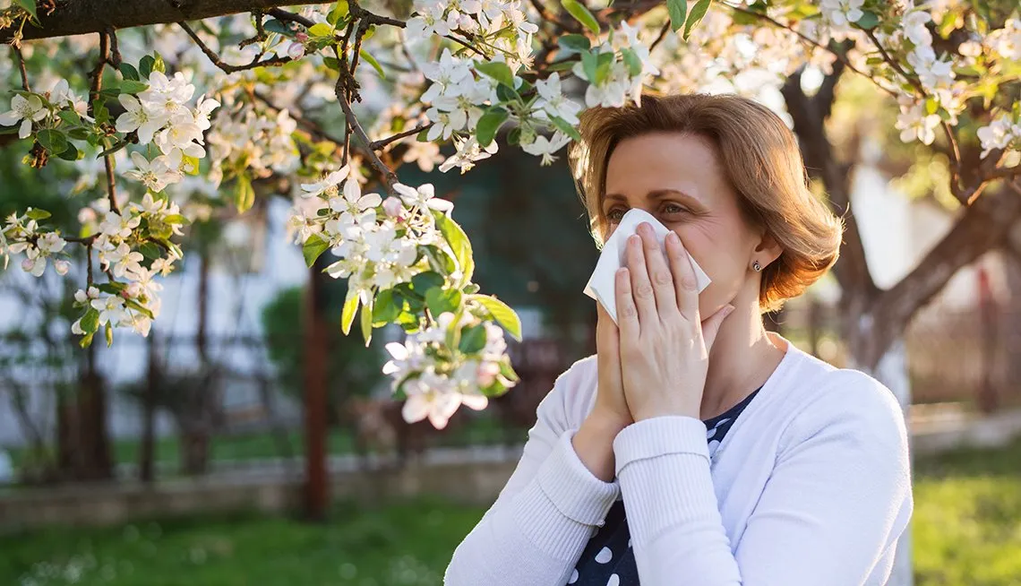 mulher com alergia perto de planta