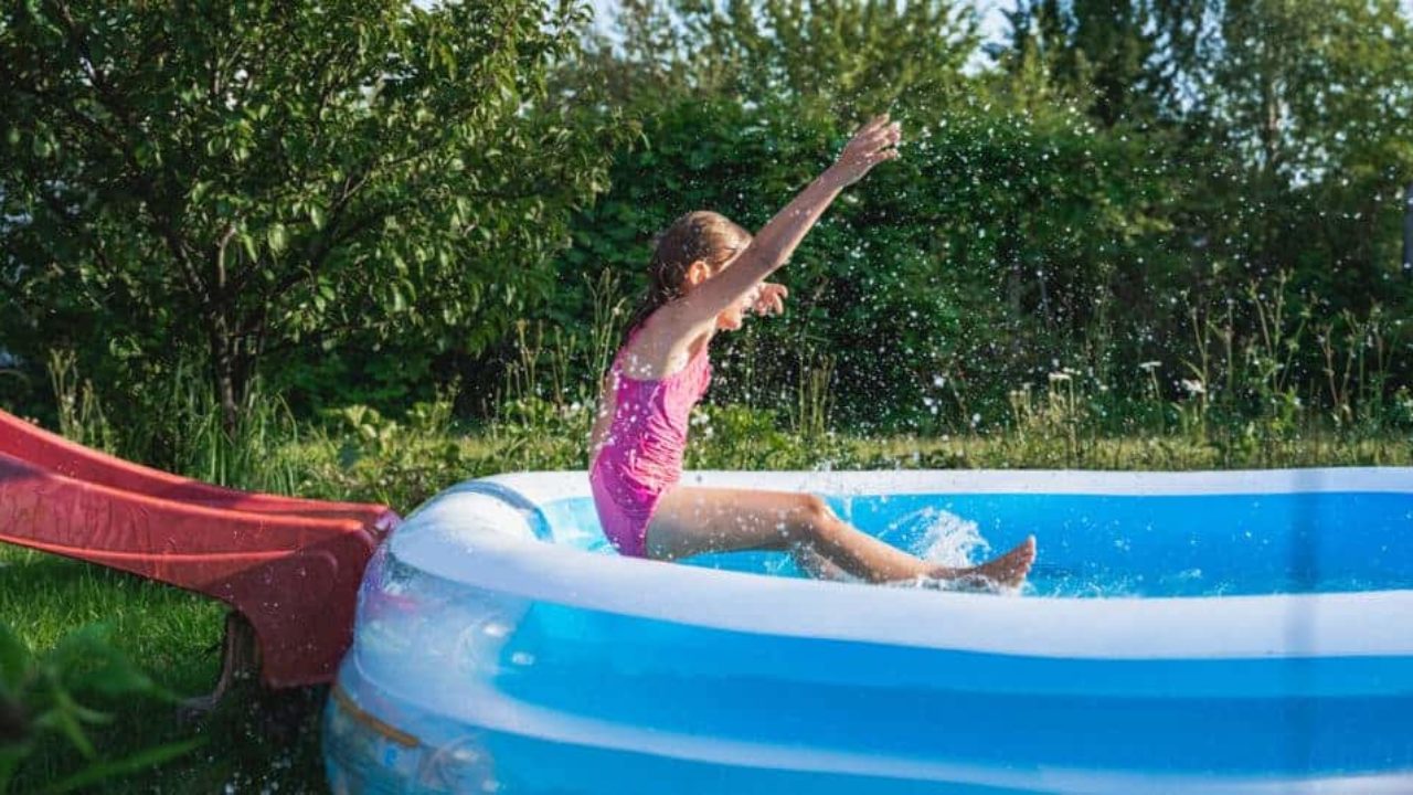 criança se jogando em piscina de plástico