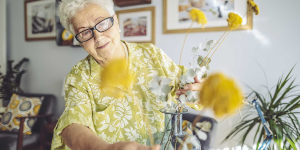 senhora trocando flores de vaso