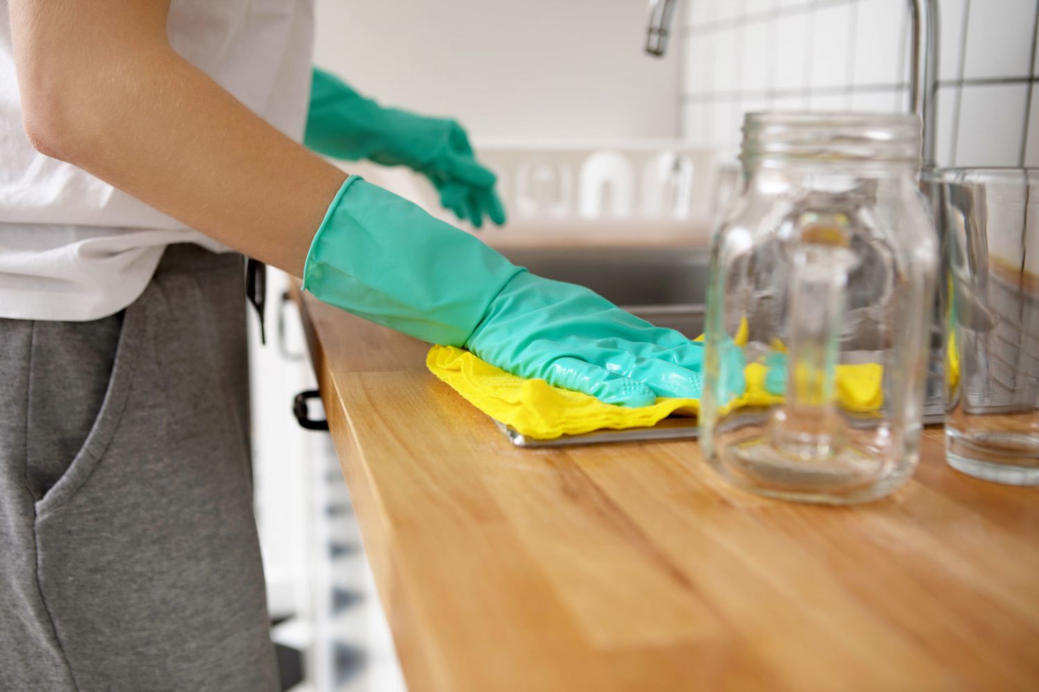 pessoa limpando bancada e pia da cozinha