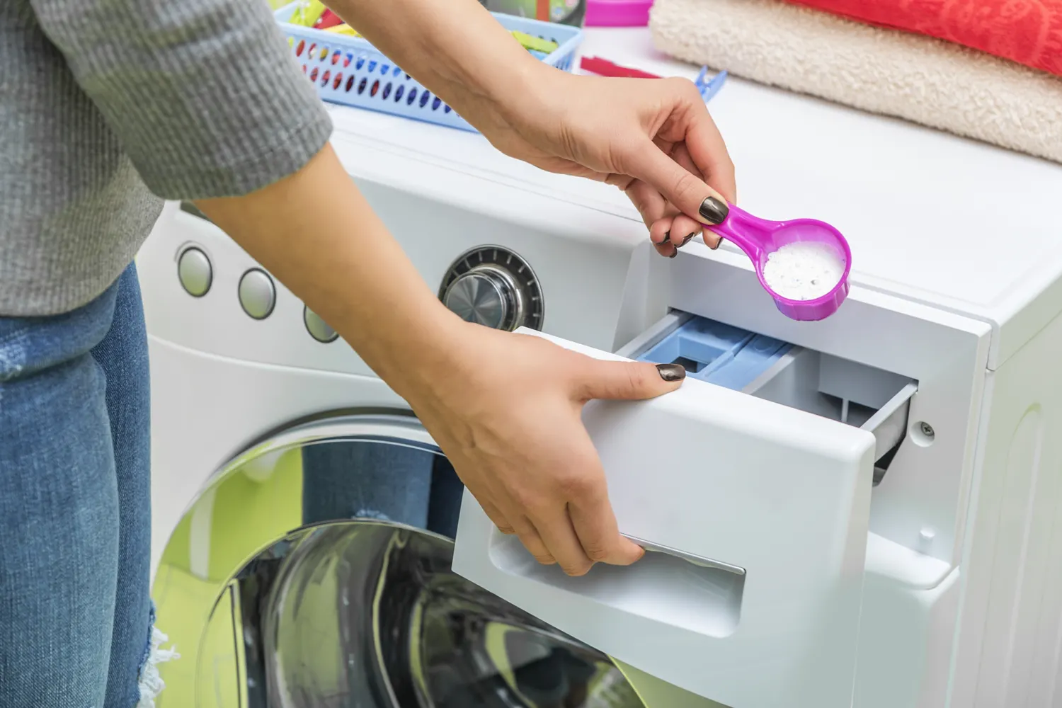 pessoa colocando sabão em dispenser da máquina de lavar