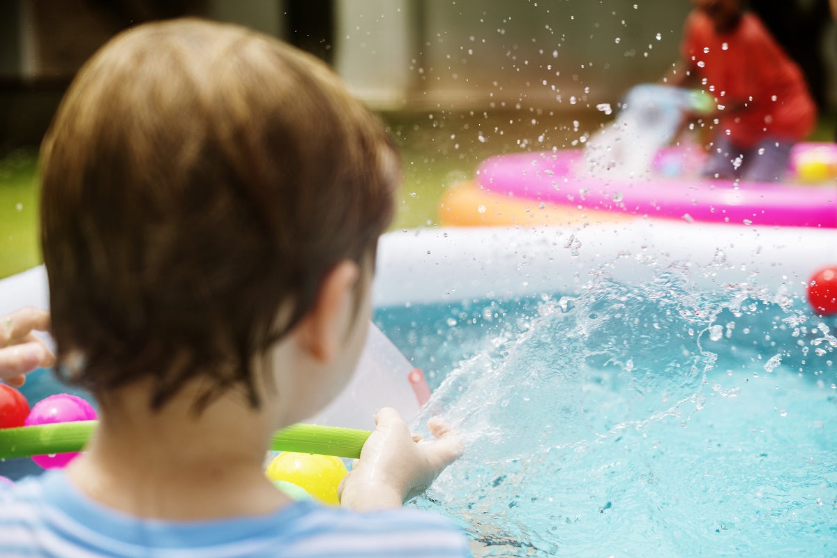 criança em piscina de plástico