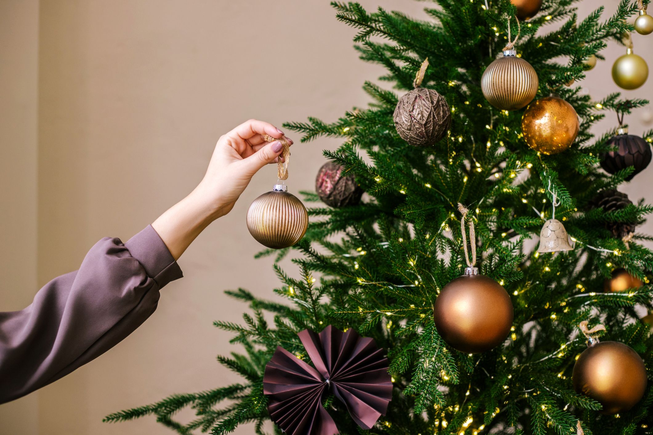 pessoa colocando bolinhas na árvore de natal