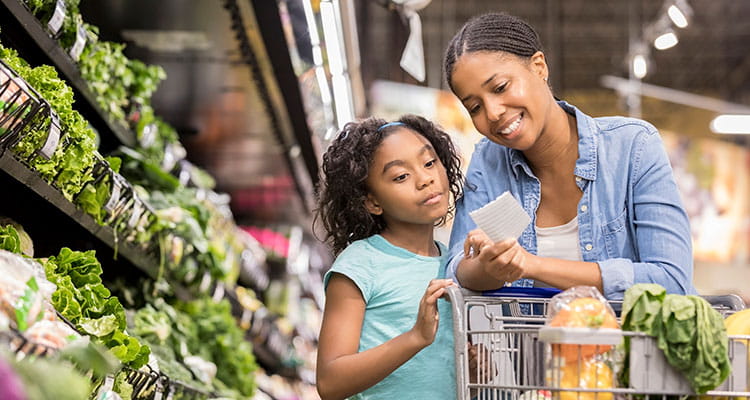 mãe e criança fazendo compras em supermercado