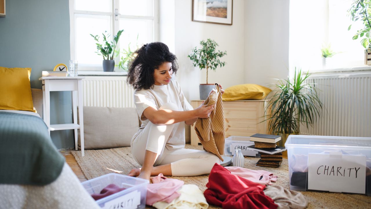 mulher separando roupas para doação