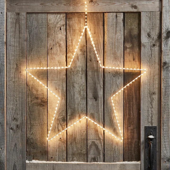 adorno de estrela luminosa em porta rústica para natal